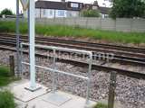 Pedestrian safety handrails fitted by railway track with residential house in the far left 