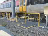 yellow powder coated pedestrian safety barrier outside of train on platform in Queensland