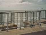 Interclamp handrail system fitted on sea wall to protect pedestrians. Calm ocean behind the handrails 