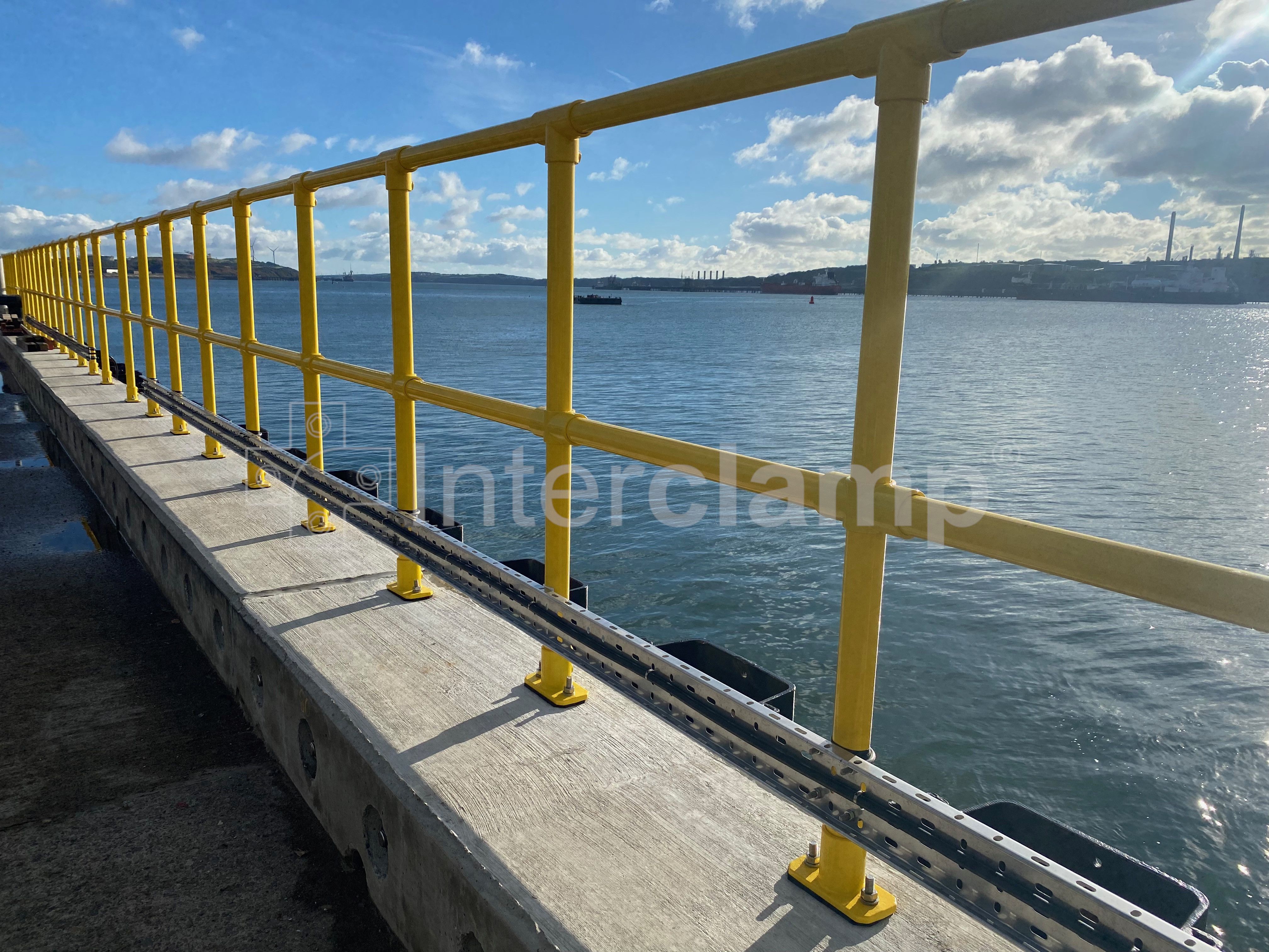 Interclamp key clamp double rail system, powdered coated in safety yellow.  Installed on the perimeter of a jetty.